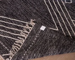 Grand tapis ethnique noir motifs brodés blancs 
